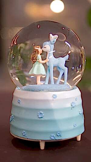 Genç kız ve ceylanlı kar küresi